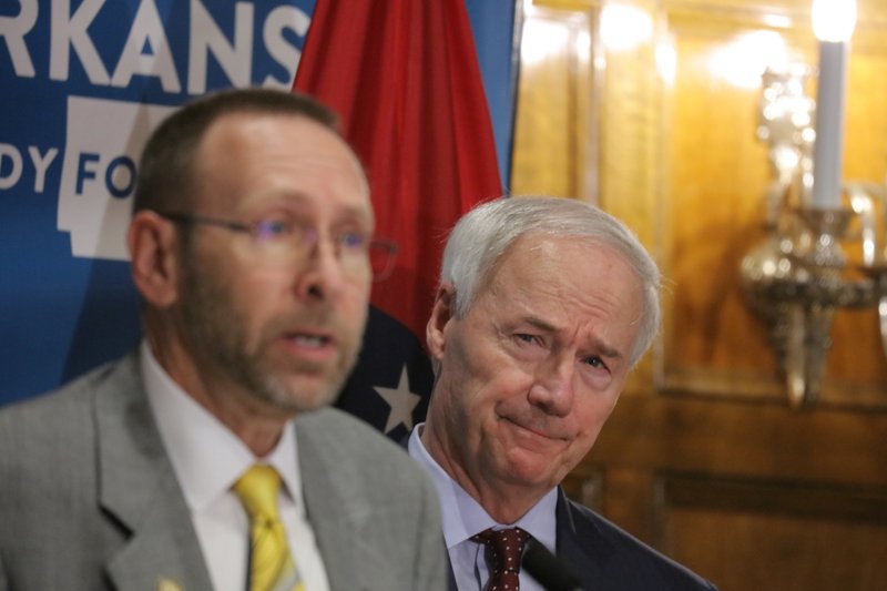 State Health Secretary Nate Smith and Gov. Asa Hutchinson discuss the spike in coronavirus cases Tuesday. “It’s put Phase Two on pause for now,” Hutchinson said. More photos at arkansasonline. com/63covbrief/. 
(Arkansas Democrat-Gazette/ John Sykes Jr.) 