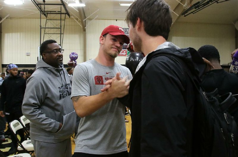 Joe T. Robinson linebacker JT Towers (middle) receives congratulations from friends after signing a national letter of intent to play for the University of Arkansas in February. Towers didn’t let a toe injury keep him from leading the Senators to a Class 4A state championship. (Arkansas Democrat-Gazette/Thomas Metthe) 