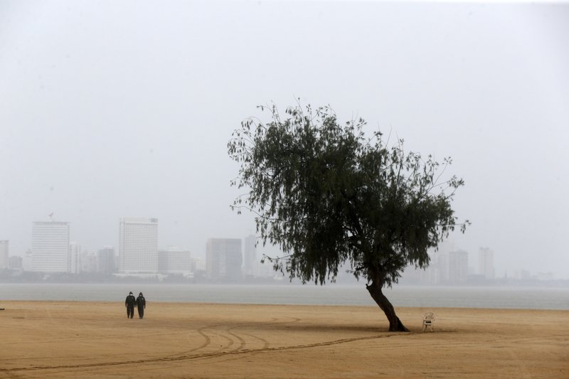 Police officers patrol a deserted beach before Cyclone Nisarga makes landfall in Mumbai, India, Wednesday, June 3, 2020. A storm in the Arabian Sea off India's west coast intensified into a severe cyclone on Wednesday, gathering speed as it barreled toward India's financial capital of Mumbai. Nisarga was forecast to drop heavy rains and winds gusting up to 120 kilometers (75 miles) per hour when it makes landfall Wednesday afternoon as a category 4 cyclone near the coastal city of Alibagh, about 98 kilometers (60 miles) south of Mumbai, India's Meteorological Department said. (AP Photo/Rajanish Kakade)