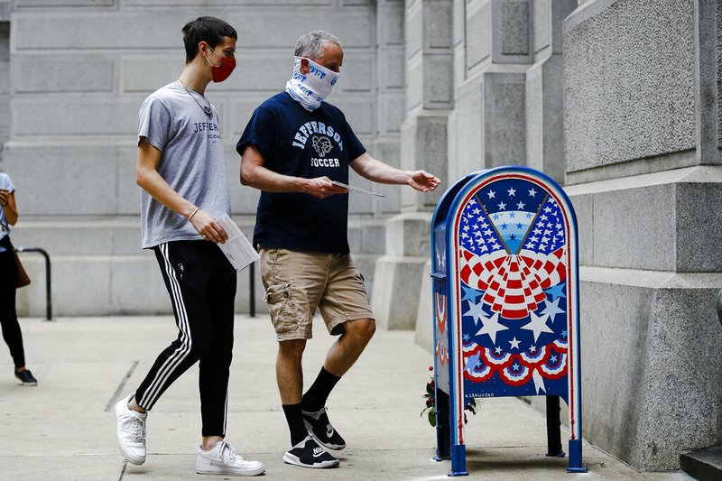 Benjamin Graff (right) and his son Jacob Graff, 19, drop off their mail-in ballots for the Pennsylvania primary in Philadelphia on Tuesday, June 2, 2020.