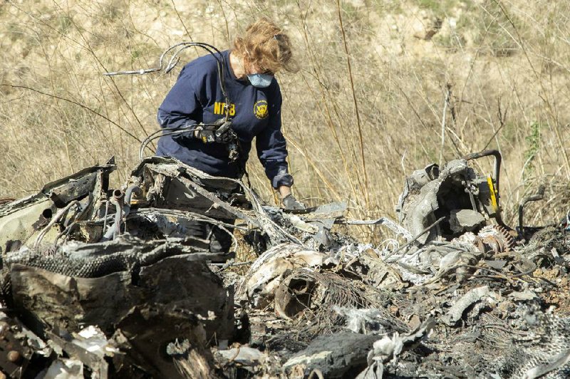 In this Jan. 27 photo, released by the National Transportation Safety Board, investigator Carol Hogan examines wreckage of a helicopter crash near Calabasas, Calif. The crash killed former NBA basketball player Kobe Bryant, his 13-year-old daughter, Gianna, and seven others.
(NTSB/James Anderson)
