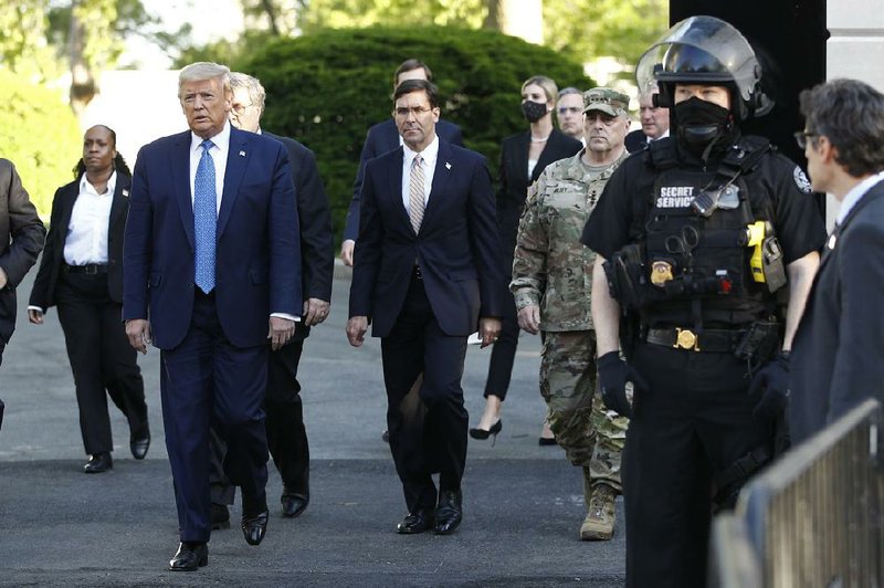 Defense Secretary Mark Esper (center) joins President Donald Trump and other officials Monday on a walk from the White House to nearby St. John’s Church. Esper said Tuesday that he didn’t know the president was going to make remarks outside St. John’s, a historic church where a small fire was set the previous day.
(AP/Patrick Semansky)
