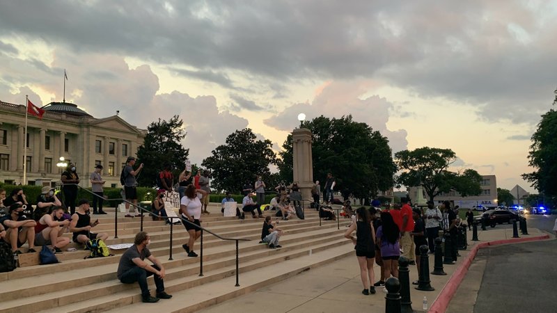 Protesters sit on the steps of the state Capitol in Little Rock at about 8:30 p.m. Friday, June 5, 2020. The city had set a 10 p.m. curfew for Friday, two hours later than the 8 p.m. curfew from the previous nights.