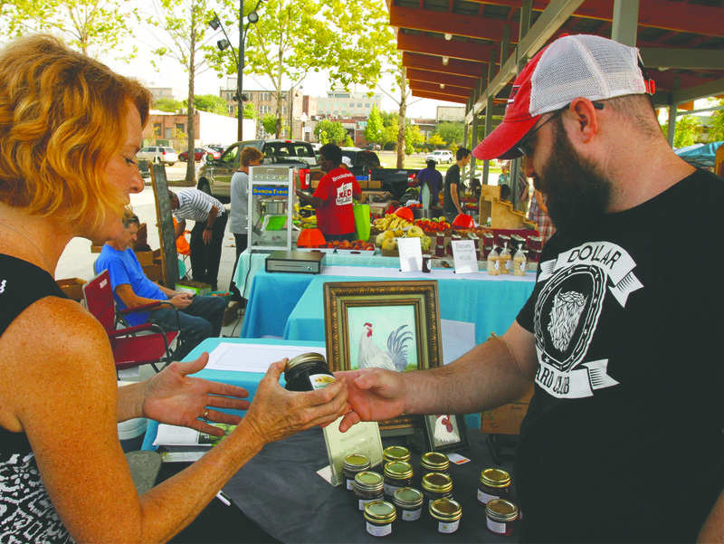 This 2019 file photo shows a MAD Farmers Market patron speaking with a market vendor. The MAD Farmers Market will open on Saturday, June 13, with social distancing guidelines in place in light of the ongoing COVID-19 pandemic. (News-Times file)