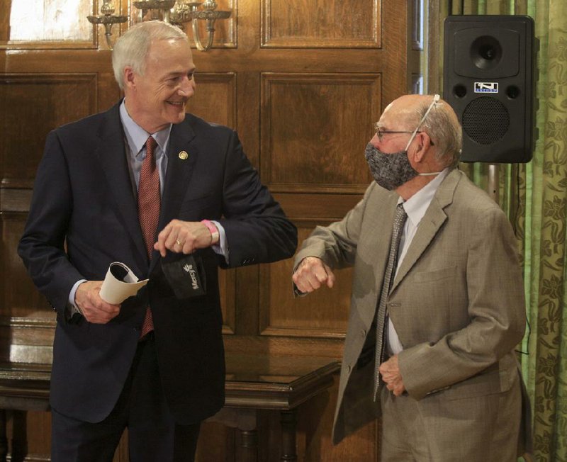 Gov. Asa Hutchinson, left, bumps elbows with Dr. Glen Baker, director of the Arkansas Department of Health Public Health Lab, Friday June 5, 2020 following the daily COVID-19 briefing at the state Capitol. Baker will turn 90 on Sunday, and Hutchinson said he believes Baker to be the oldest state employee currently working. (Arkansas Democrat-Gazette/Staton Breidenthal)