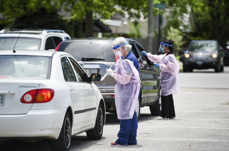 Nurse Pansy James (center) administers a covid-19 test, Saturday, May 23, 2020 at the Center for Nonprofits parking lot in Springdale. 