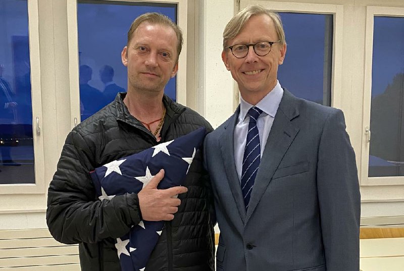 In this image provided by the State Department, Michael White holds an American flag as he poses for a photo Thursday with U.S. special envoy for Iran Brian Hook at the Zurich, Switzerland, airport after White’s release from Iran.
(AP/State Department)