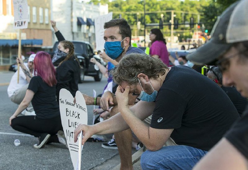 Protesters kneel in a moment of silence Thursday to remember George Floyd, who died in police custody in Minneapolis, during a Black Lives Matter protest on the downtown Harrison square.
(NWA Democrat-Gazette/Ben Goff)