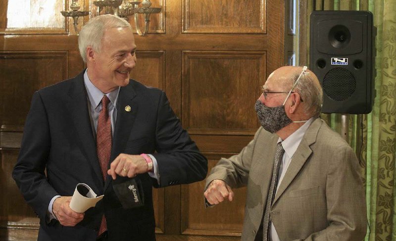 Gov. Asa Hutchinson bumps elbows with Dr. Glen Baker, director of the state Department of Health’s Public Health Lab, after the daily coronavirus briefing Friday at the state Capitol. More photos at arkansasonline.com/66governor/.
(Arkansas Democrat-Gazette/Staton Breidenthal)