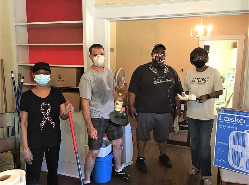 New Creations Life Center board members and volunteers clean a local residence that will be used as home base to assemble care packages that will be delivered later this week to the homeless in El Dorado. From left are Yvette Napoleon, Doug Stanton, Darwin Moore and Mary Snowden. (Contributed photo)