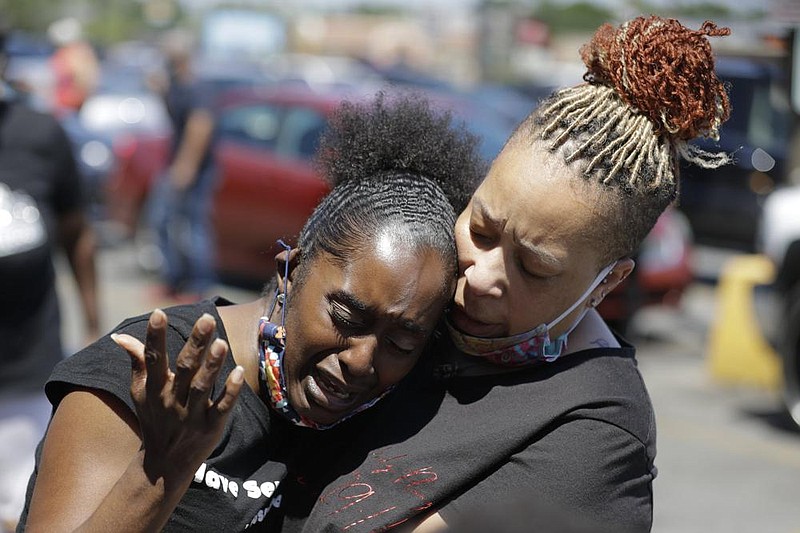 Women console each other last week in Louisville, Ky., near the site where David McAtee was fatally shot by police.
(AP/Darron Cummings)