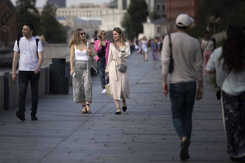 People walk Tuesday along an embankment of the Moscow River as the Russian capital ends its coronavirus lockdown. More photos at arkansasonline.com/610moscow/. (AP/Alexander Zemlianichenko) 