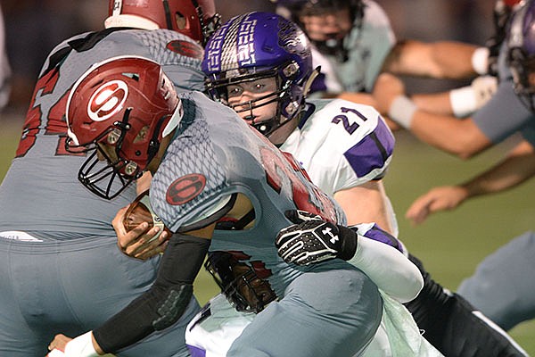 Springdale running back Gilberto Dominguez (left) is brought down Friday, Oct. 25, 2019, by Fayetteville defender Kaiden Turner (21) during the first half of play at Jarrell Williams Bulldog Stadium in Springdale.