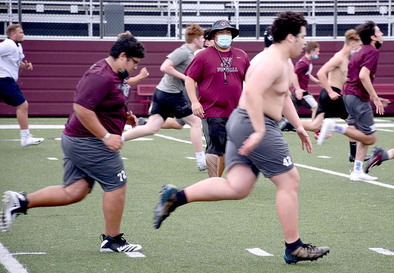 Siloam Springs assistant football coach Ehldane Labitad looks on as the Panthers run sprints during football practice last week at Panther Stadium.

