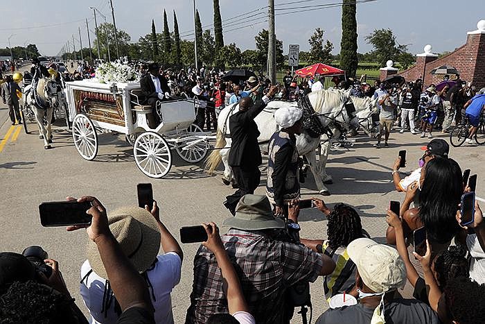 A horse-drawn hearse carrying George Floyd’s coffin arrives with the funeral procession Tuesday at Houston Memorial Gardens cemetery in Pearland, Texas. (AP/Eric Gay) 