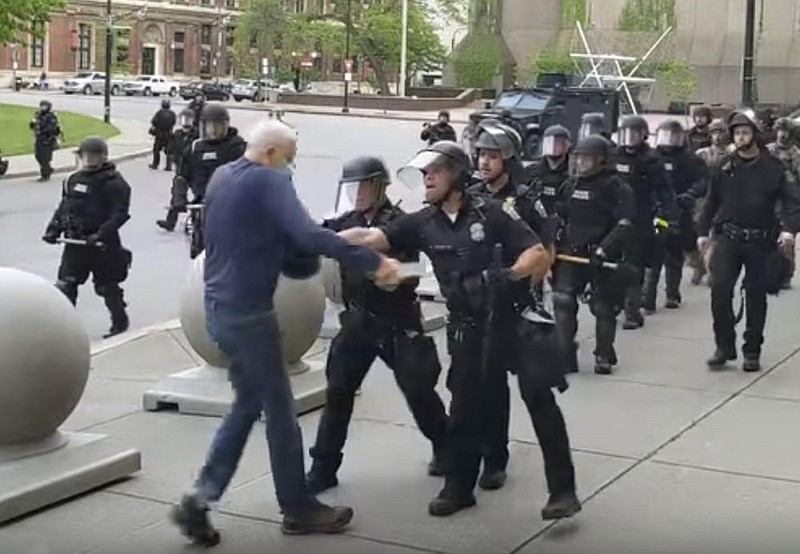 In this image from video, a Buffalo, N.Y., police officer appears to shove protester Martin Gugino during a demonstration Thursday. Gugino lay motionless and bleeding after falling, and he was hospitalized. In a tweet, President Donald Trump questioned whether Gugino was part of “a set up.” (AP/WBFO/Mike Desmond) 
