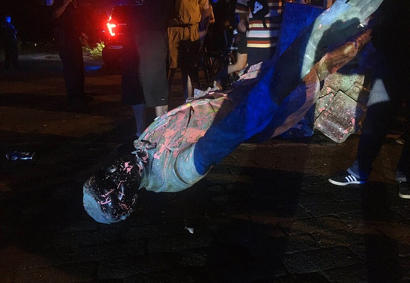 The statue of Confederate President Jefferson Davis is splattered with paint after it was toppled Wednesday night, June 10, 2020, along Monument Drive in Richmond, Va.
