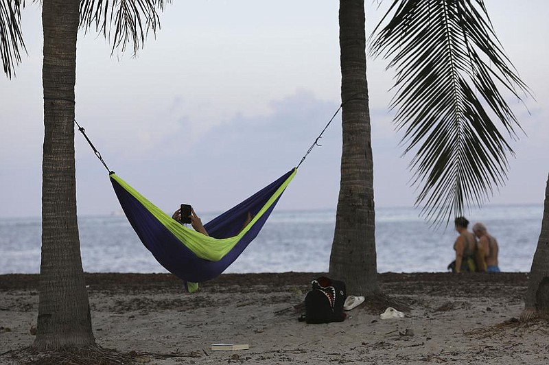 A woman relaxes in a hammock Wednesday at Crandon Park beach in Miami. Beaches in Miami-Dade County opened with restrictions Wednesday after having been closed for 12 weeks.
(AP/Lynne Sladky)