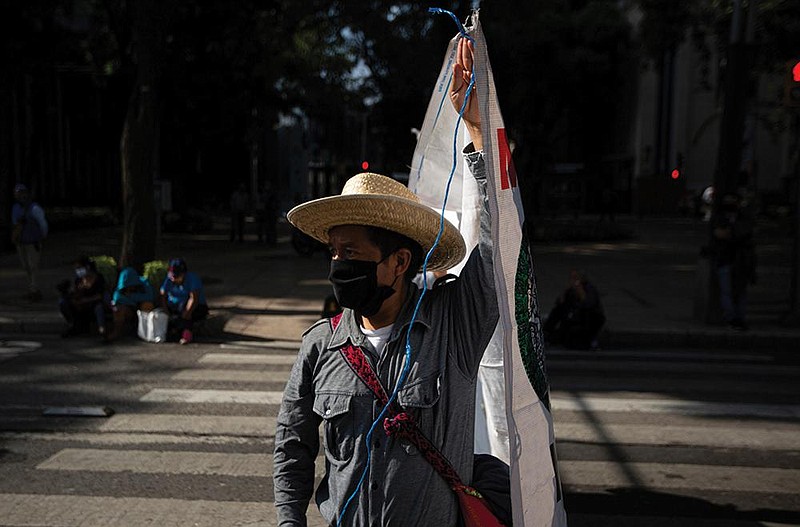 An artisan protests Wednesday along a street in Mexico City. Hundreds of artisan families are asking the government for financial help after the city closed their market as part of the coronavirus lockdown.
(AP/Fernando Llano)
