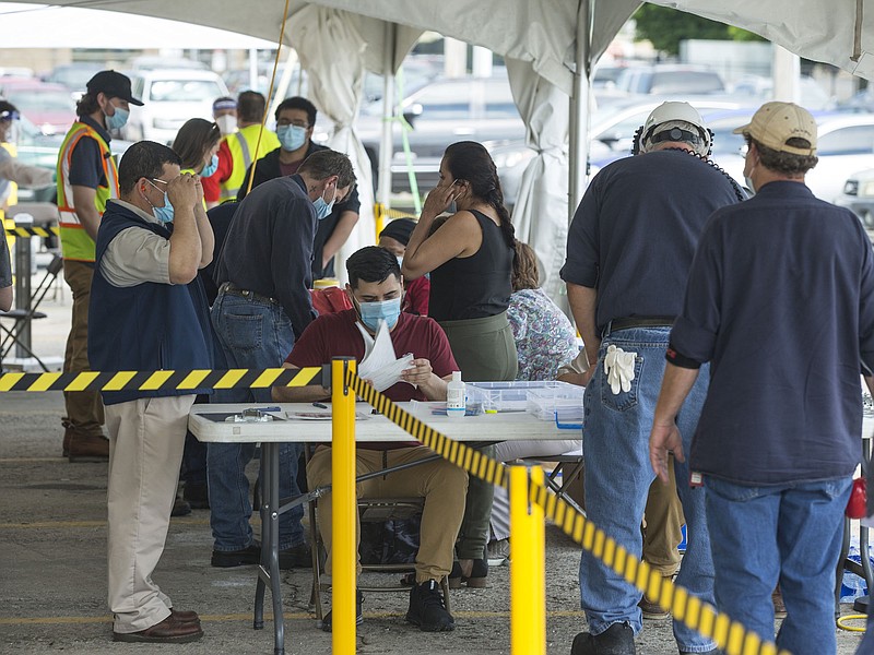 Tyson employees line up Tuesday, June 9, 2020, at a covid-19 testing station set up outside the Tyson Foods Chick-N-Quick plant in Rogers. 
(NWA Democrat-Gazette/Ben Goff)