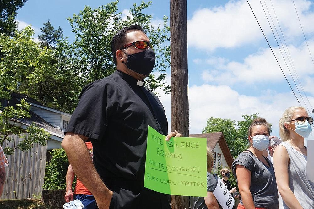 Father Rubén Quinteros, pastor of Immaculate Heart of Mary Church in North Little Rock (Marche), holds a sign at “Take a Knee — A Rally for Justice” on June 6 at Theressa Hoover United Methodist Church in Little Rock.
(Special to the Democrat-Gazette/Aprille Hanson via Arkansas Catholic)