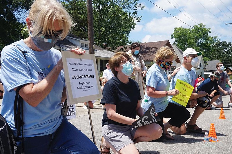 Pax Christi Little Rock members Mary Hunt (left), Marian Paquette, Drs. Sherry Simon and George Simon take a knee for prayer and a stance against police brutality at a June 6 rally in Little Rock.
(Special to the Democrat-Gazette/Aprille Hanson via Arkansas Catholic)