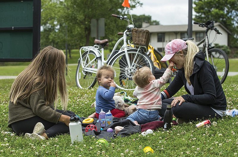 Sarah Schutte (from left), 1-year-old twins Knox Breeden and Kennedy Breeden, and Mallory Breeden, all of Bentonville, take a break Wednesday at Horsebarn Trailhead Park in Rogers during a bike ride on the hard-surface trails. Video at arkansasonline.com/614greenway/.
(NWA Democrat-Gazette/Ben Goff)