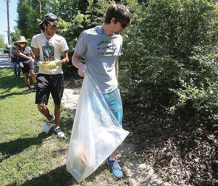 Volunteers  Cody  Carter  (from  front),  Marcus  Hunter  and  LaToya Bankhead pick up trash Saturday in the neighborhood  around Central High School in Little Rock.        
(Arkansas Democrat-Gazette/Thomas Metthe)