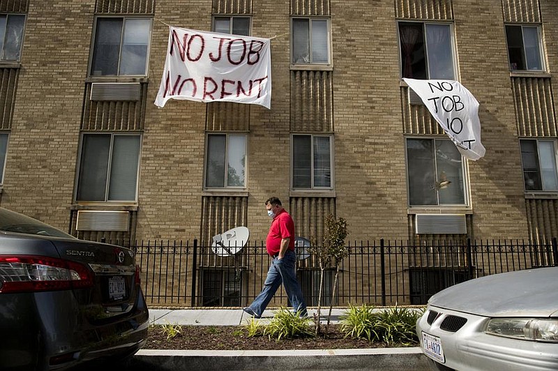 Signs reading “no job no rent” hang from an apartment building last month in Washington. (AP/Andrew Harnik) 