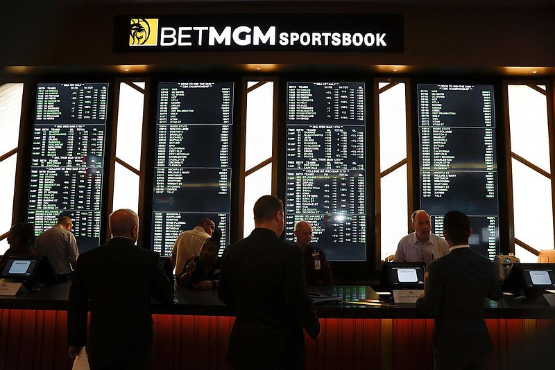 Employees work at the MGM Grand Detroit casino sports book in March. Sports bettors are sitting on a large amount of money as the coronavirus has shut down major sports leagues, and analysts say some of those gamblers are turning to the stock market.
(AP/Paul Sancya)