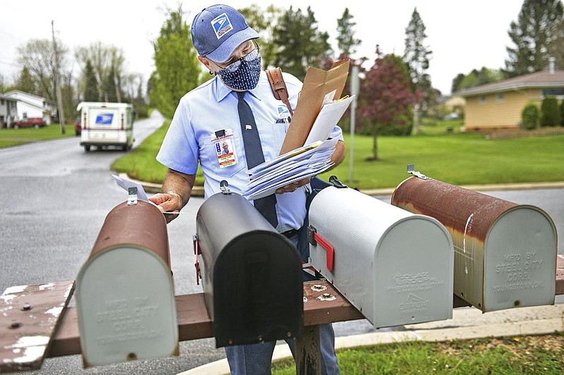 Stan Niton, a U.S. Postal Service letter carrier, sorts through the mail last month on his route in Richland Township, Pa. The Postal Service’s future has been the focus of a growing political battle.
(The Tribune-Democrat/Thomas Slusser)