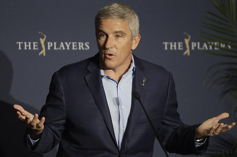 PGA Tour Commissioner Jay Monahan reacts to a question during a news conference at The Players Championship golf tournament, in Ponte Vedra Beach, Fla.,  early Friday, March 13, 2020. The PGA Tour first said there would be no fans. Now there will be no players. In a late Thursday night decision, the PGA Tour canceled the rest of The Players Championship and said it would not play the next three weeks. (AP Photo/Chris O'Meara)