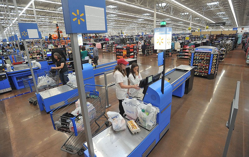 Sydney Walsh (left) and Channing Daniels use the self checkout lanes at the Pleasant Grove Walmart in Rogers in this Sept. 30, 2015, file photo.