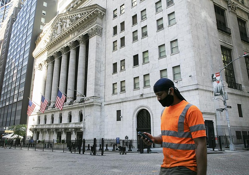 A man walks past the New York Stock Exchange on Tuesday in New York. Companies that would benefit most from a reopening economy again led the market in trading on Wall Street, as investors look for a rebound in activity. (AP/Mark Lennihan) 