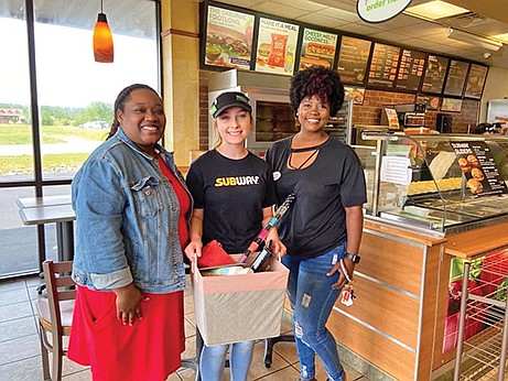 Cassie Halloway, left, and Victoria Stender, right, surprise Rebecca Reardon with some gifts for her dorm. Reardon graduated from Vilonia High School this spring and has worked at Subway for a year. She will attend the University of Arkansas Community College at Morrilton in the fall and plans on majoring in the medical field.