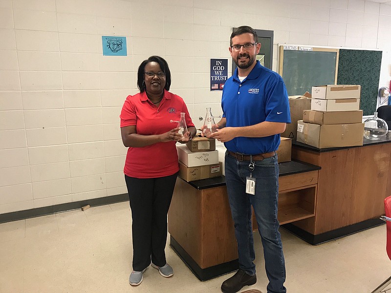 LANXESS donated several boxes of lab beakers and other glassware to Strong High School for science classes recently. Pictured are Kimberly Thomas, Superintendent of the Strong School District, and Mark Day, public relations and land manager for LANXESS.(Contributed)