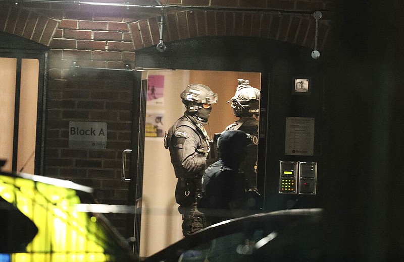 Armed police officers work at a block of flats off Basingstoke Road in Reading, England, after an incident at Forbury Gardens park in the town center on Saturday, June 20, 2020. Several people were injured in a stabbing attack in the park, and British media said police were treating it as “terrorism-related.”