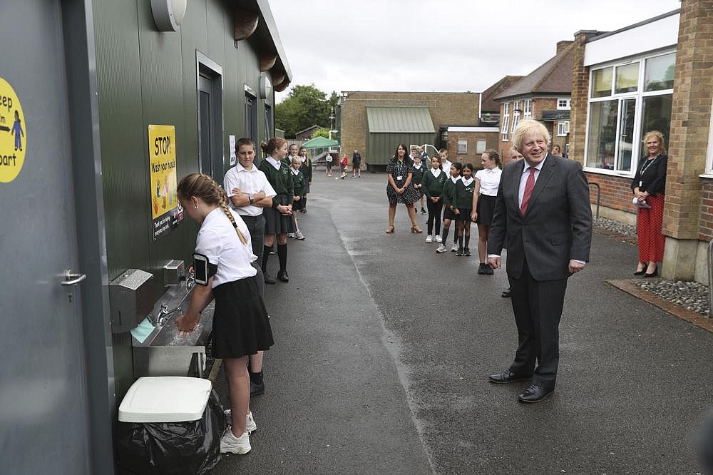 British Prime Minister Boris Johnson waits in line to wash his hands Friday at a playground at Bovingdon Primary School in Bovingdon, Hemel Hempstead, England. Britain lowered its coronavirus threat level on Friday, saying its national outbreak is getting under control.
(AP/Steve Parsons)