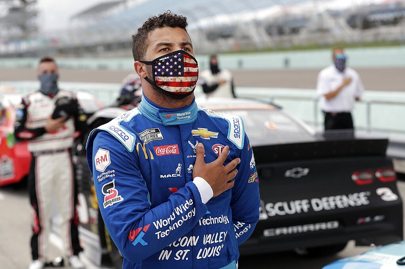 Bubba Wallace stands for the national anthem before a NASCAR Cup Series auto race in Homestead, Fla., in this June 14, 2020, file photo.