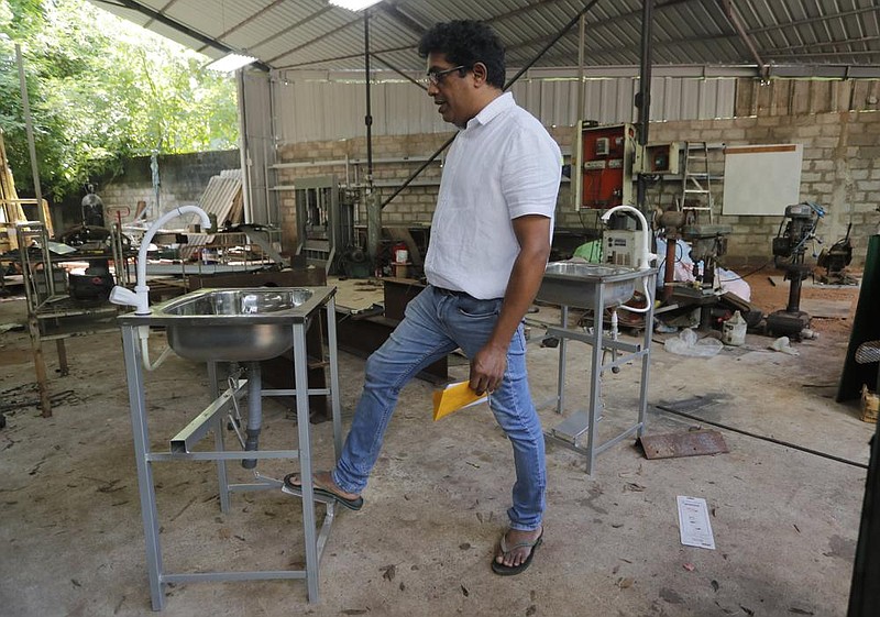 Entrepreneur Nishantha Abeyrathne checks a paddle sink that is made at his workshop in Path- thanduwana village in Sri Lanka.
(AP/Eranga Jayawardena) story.lead_photo.caption