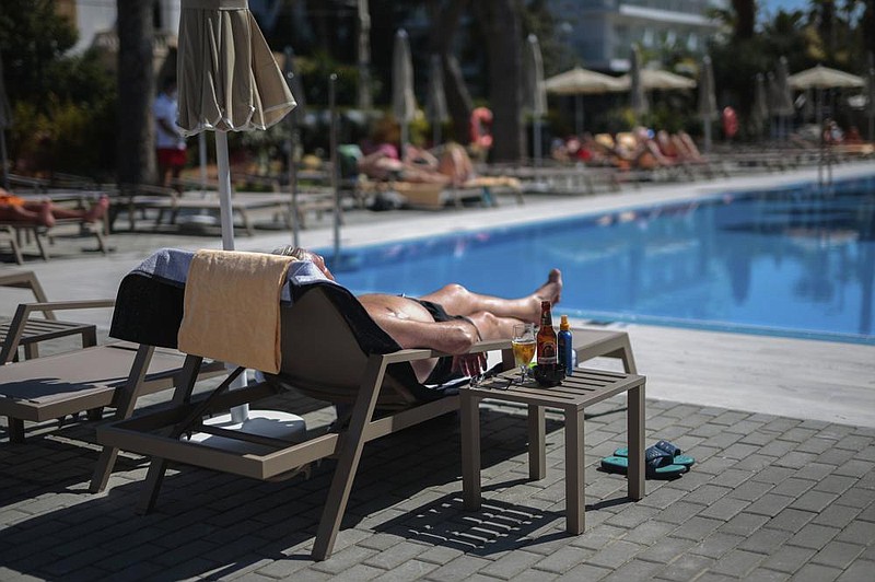 A German tourist sunbathes at the Riu Concordia hotel swimming pool in Palma de Mallorca, Spain, in mid-June. (AP/Joan Mateu) 