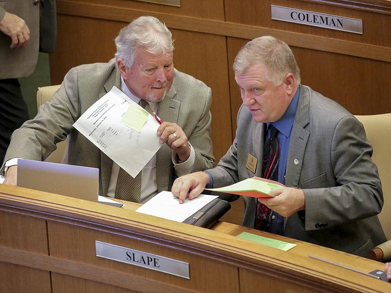 FILE — Representatives Stan Berry, left, (R), Dover, and Keith Slape, right, (R), Compton, look through paperwork at the conclusion of the house of representatives session in this June 21, 2020 file photo. (Arkansas Democrat-Gazette file photo)