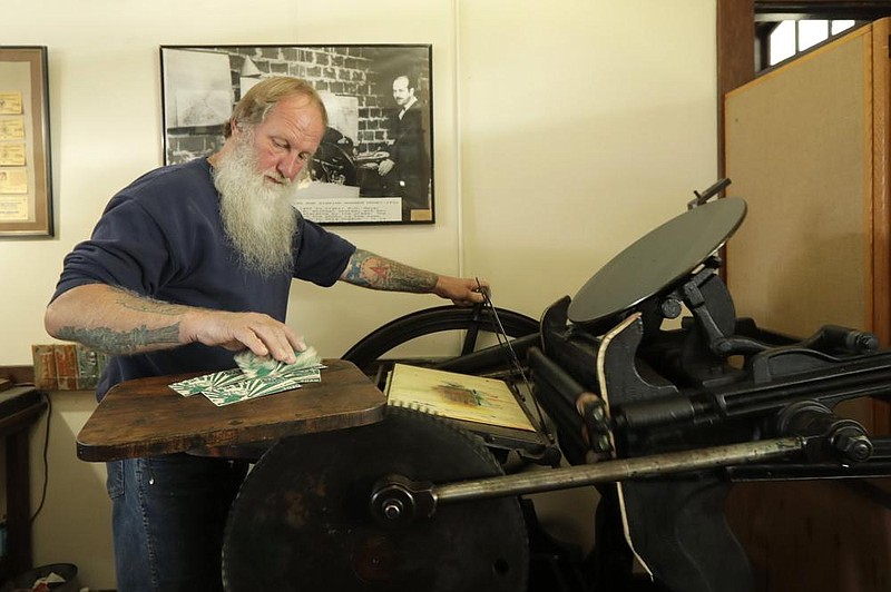 Loren Ackerman prints wooden money on an 1890s-era press in Tenino, Wash. (AP/Ted S. Warren) 
