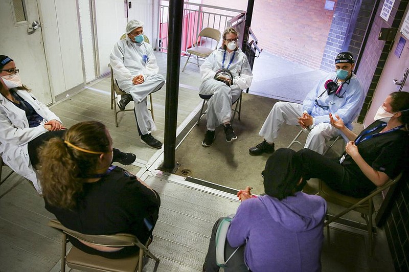 Hospital workers sit for a group counseling session in late May at Elmhurst Hospital in New York City to talk about their experiences dealing with coronavirus patients. “I’m still scared,” one doctor said. (AP/Robert Bumsted) 