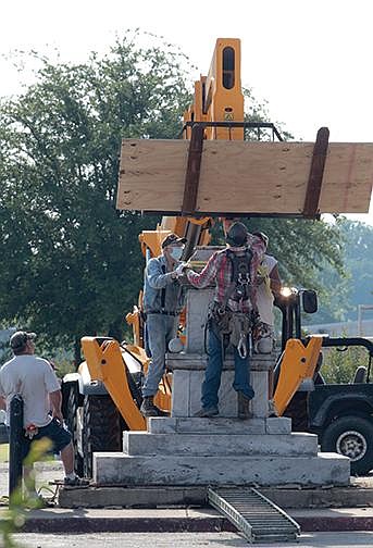 Workers take down a 20-foot-tall Confederate statue on the Jefferson County Courthouse grounds in Pine Bluff on June 20.
(Arkansas Democrat-Gazette/Dale Ellis)