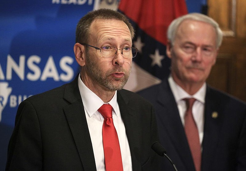 Health Secretary Nate Smith (left) on Monday defended Gov. Asa Hutchinson’s decision not to issue a mask order, saying it would be useless if people chose to out it. More photos at arkansasonline. com/623governor/. (Arkansas Democrat-Gazette/Staton Breidenthal) 
