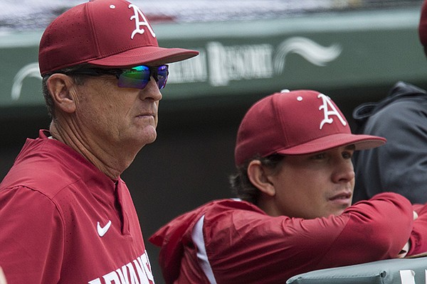 Arkansas coach Dave Van Horn (left) and student assistant Harrison Heffley watch from the dugout during a game against LSU on Saturday, May 11, 2019, in Fayetteville.