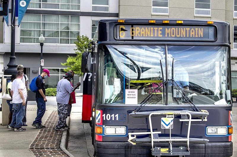 Riders board a bus through the rear door as a coronavirus precaution in June at the Rock Region Metro Transit Center in downtown Little Rock. (Arkansas Democrat-Gazette/Stephen Swofford) 
