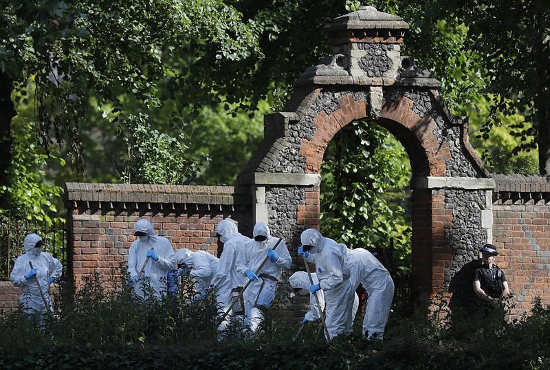 Police forensic officers search Monday near the scene of the stabbing attack in Reading, England. More photos at arkansasonline.com/623reading/. (AP/Kirsty Wigglesworth) 