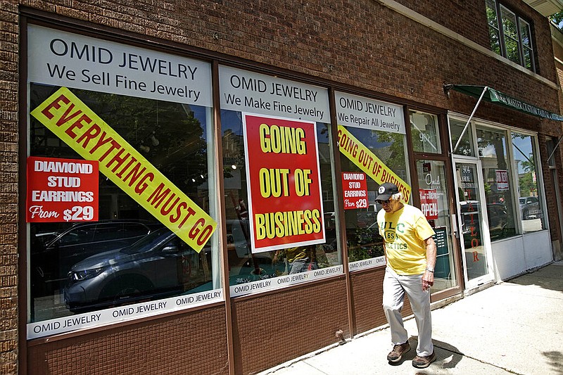 A man walks past a retail store that is going out of business due to the coronavirus pandemic in Winnetka, Ill., Tuesday, June 23, 2020. 